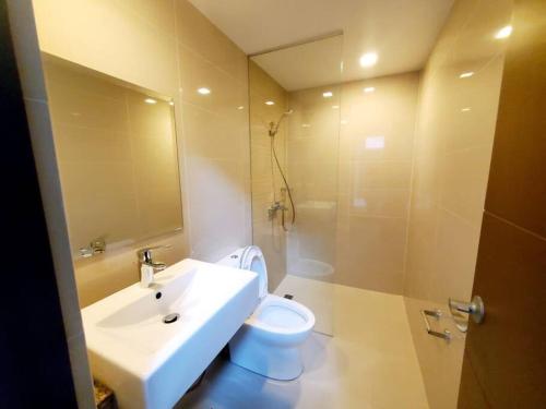 uma casa de banho com um lavatório, um WC e um espelho. em High speed internet - Cozy 1BR fully Furnished em Manila