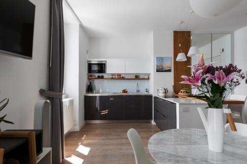 a kitchen with a table and a vase of pink flowers at NELL'A COMO in Griante Cadenabbia