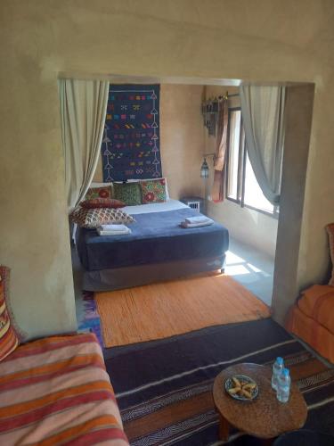 a small bedroom with a bed and a couch at Les Jardins de Skoura in Skoura
