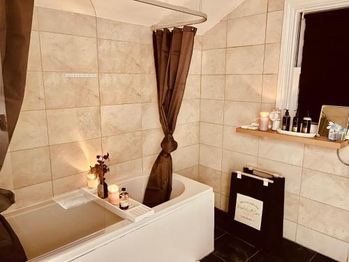 a bathroom with a tub and a shower curtain at Cambridge Heritage Apartments in Cambridge