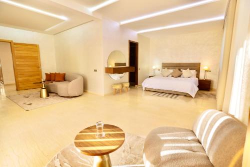 a bedroom with a bed and a living room at *Villa de luxe à Marrakech, vue sur les montagnes* in Marrakech