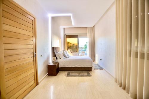 a bedroom with a bed and a door with a window at *Villa de luxe à Marrakech, vue sur les montagnes* in Marrakech