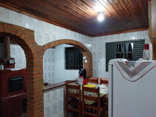 cocina con arcos de ladrillo y nevera en Hospedagem Manacás, en Alagoa