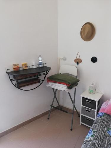 a room with a chair and a shelf on the wall at Ciao b&b in Selva di Fasano