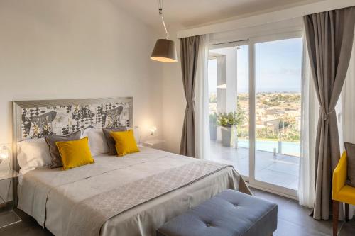 a bedroom with a large bed and a large window at Villa Kalòn Sicily with private pool sea view in Marsala