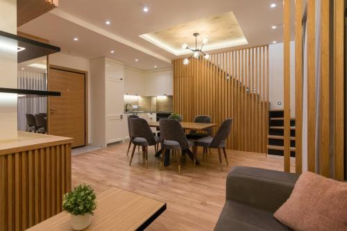 a dining room and living room with a table and chairs at Tara Lux apartmani in Kaludjerske Bare