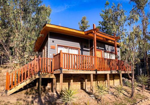a large wooden house with a large deck at Cabañas Boutique Faldeos de La Lajuela in Santa Cruz