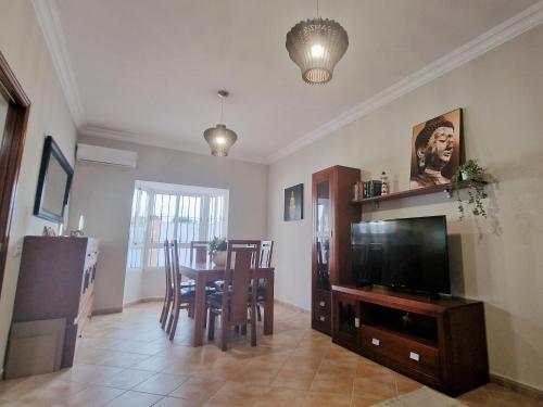 a living room with a dining room table and a television at Villas Luins in Chiclana de la Frontera