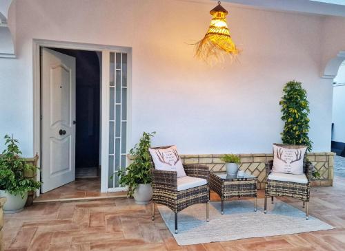 a patio with chairs and a table and a light at Villas Luins in Chiclana de la Frontera