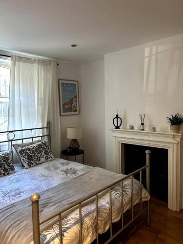a bedroom with a bed with a fireplace and a bedsenalsenalsenal at Remarkable 2-Bed House in London in London