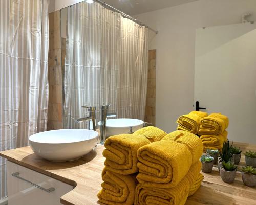 La salle de bains est pourvue de serviettes jaunes sur un comptoir avec lavabo. dans l'établissement Le Gambetta Paris, à Paris