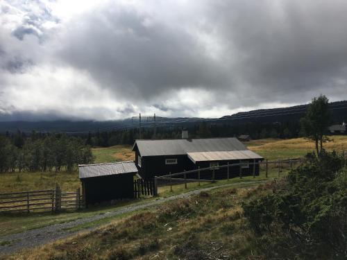 een schuur in een veld naast een hek bij Einkjerrbu cabin by Norgesbooking - in Svingvoll