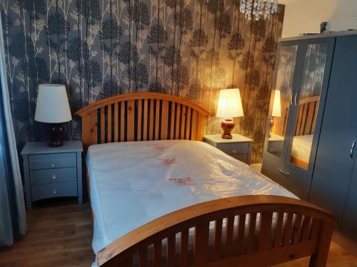 een slaapkamer met een bed met een houten hoofdeinde bij 1 Buttermere road in Lancaster