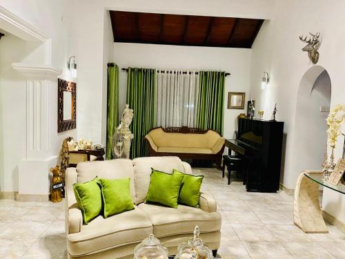 a living room with a couch and a piano at Lukshmie Villa in Ja-Ela