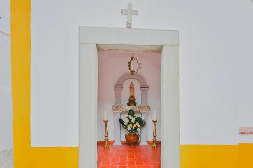 a altar in a church with two candles at Casa de Campo da Quinta da Pegada in Óbidos