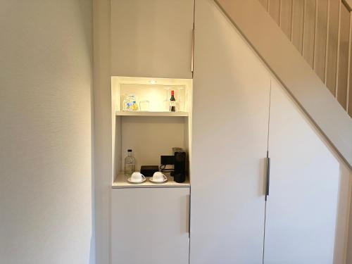 a room with a white cabinet with a coffee maker at Hotel Flora Batava in Breukelen