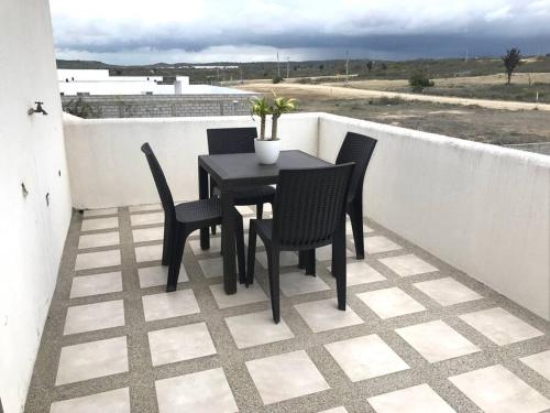 una mesa negra y sillas en el balcón en Tu casa en la playa, hermoso Alojamiento entero, en Punta Blanca