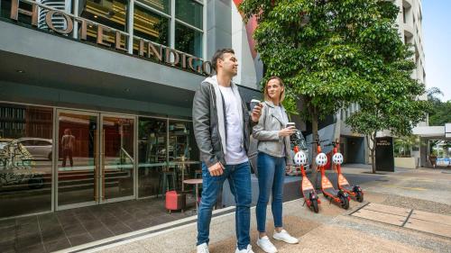 a man and a woman standing in front of a building at Hotel Indigo Brisbane City Centre, an IHG Hotel in Brisbane