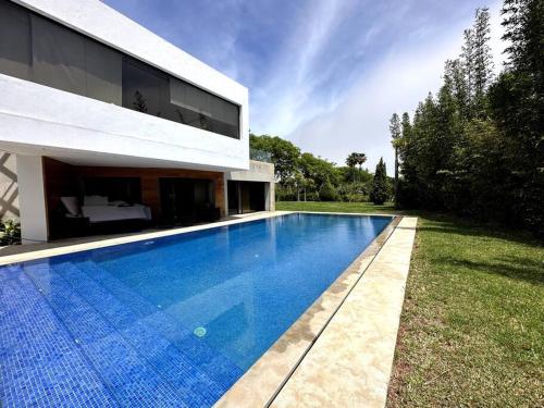 a swimming pool in the backyard of a house at Villa Sérénité Cabo Negro in Bicas