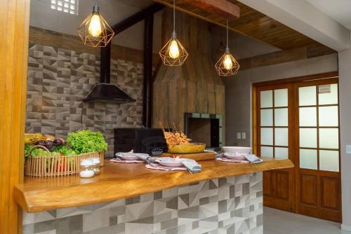 a kitchen with a counter with fruits and vegetables on it at O Recanto M&M na Praia de Fora. in Palhoça