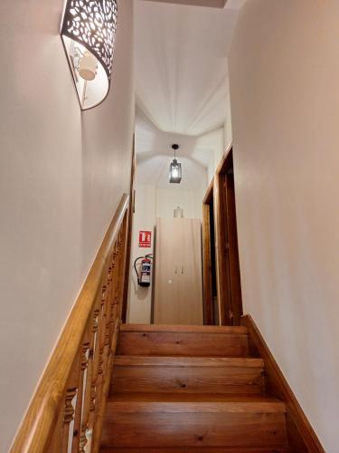 a hallway with wooden stairs and a light fixture at Entre Potes y Picos con WIFI y garaje in Turieno