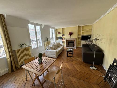 un salon avec un canapé et une table dans l'établissement Arc de Triomphe - Champs Elysées - Super emplacement - 5è étage - balcon - 60 m2, à Paris