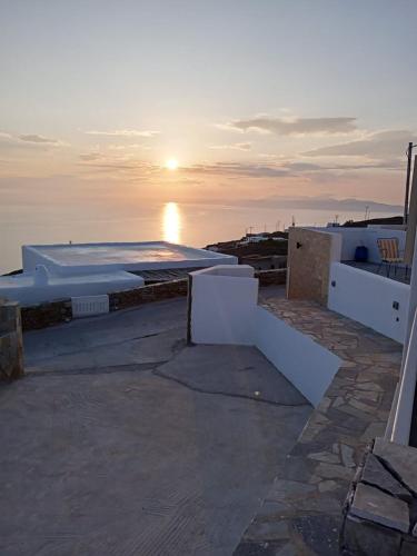 ein Sonnenuntergang über dem Meer mit weißen Gebäuden und dem Ozean in der Unterkunft Anerada sunset in Áno Meriá