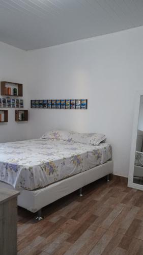 a bed in a room with a white wall at Suíte itaporanga in Santa Maria Madalena