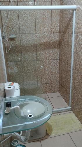 a bathroom with a glass shower with a sink at Suíte itaporanga in Santa Maria Madalena
