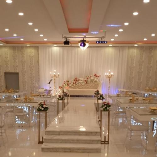 un salón de banquetes con mesas y sillas y un pastel en استراحة تحفة العروس- المدينة المنورة, en Medina