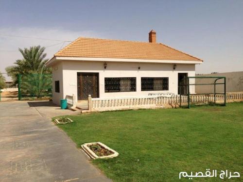 une petite maison blanche avec une cour d'herbe dans l'établissement استراحة تحفة العروس- المدينة المنورة, à Médine