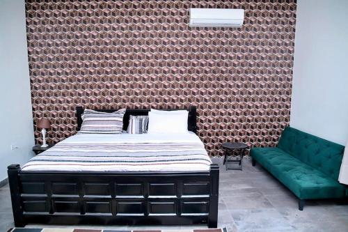 a bedroom with a bed and a green couch at Welcoming abode in the heart of Osu - Apartment 3 in Accra