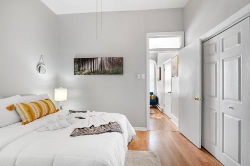 a white bedroom with a large bed and a hallway at Cozy, Charming 1-bdrm - University City in Philadelphia