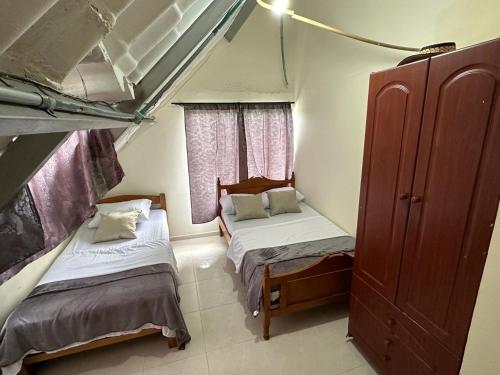 ein kleines Zimmer mit 2 Betten und einem Fenster in der Unterkunft Finca Santa Lucia, Anolaima in Anolaima