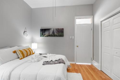 a white bedroom with a white bed and a door at Charming 1br In Univ City in Philadelphia