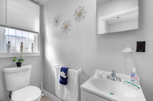 a white bathroom with a toilet and a sink at Cozy, Charming 1-bdrm - University City in Philadelphia