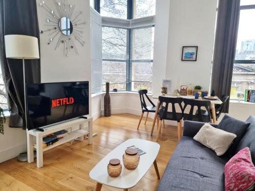 a living room with a blue couch and a tv at Shard View Apartments in London