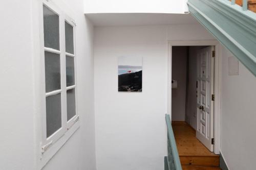 a hallway with white walls and windows and a picture on a wall at Cosy flat, heart of the city in A Coruña