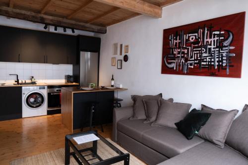 a living room with a couch and a kitchen at Cosy flat, heart of the city in A Coruña