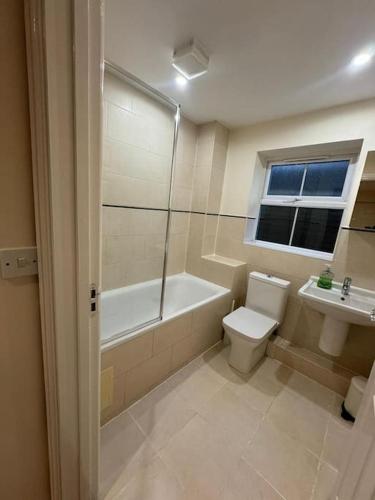y baño con bañera, aseo y lavamanos. en 2 Bedroom London Apartment, en South Norwood