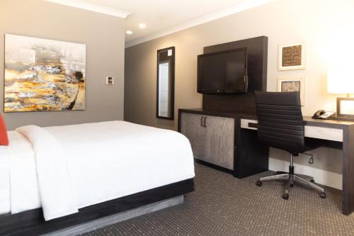 a bedroom with a bed and a desk with a computer at Crowne Plaza Fredericton Lord Beaverbrook by IHG in Fredericton