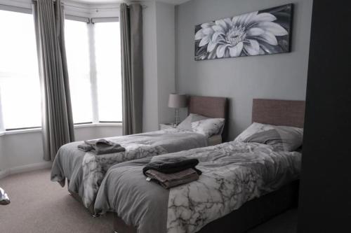 a bedroom with two beds with towels on them at Amber Apartments, FREE PARKING, 3 bedrooms, sleeps 5, 1 en-suite plus 1 bath/shower room in Swindon