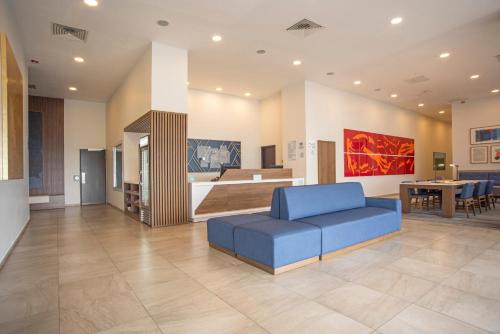 a living room with a blue couch and a kitchen at Holiday Inn Express Guadalajara Iteso, an IHG Hotel in Guadalajara