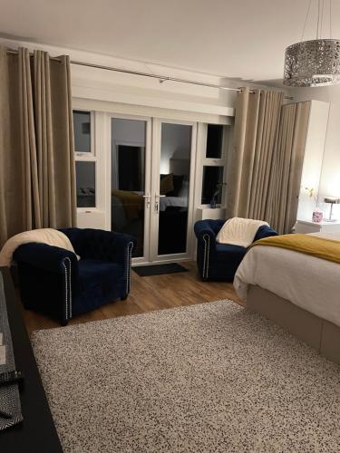 1 dormitorio con 1 cama, 1 silla y 1 sofá en Forest Path luxury Studio Apartment with large bedroom bathroom and sauna Sleeps up to 4 en Ballynahinch