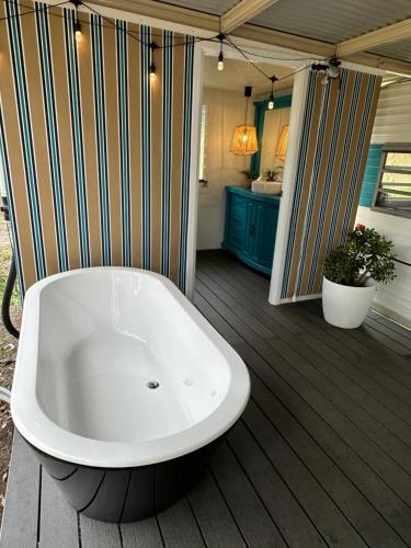 a bath tub sitting on top of a deck at Crescent Head, stylish retro caravan, deck, bathroom, private bush setting near beach in Crescent Head