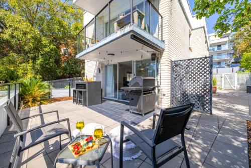 un patio con sillas, una mesa y una parrilla en Sunset Towers, 1-25 Donald St- in the heart of town with Wi-Fi and Air Con, en Nelson Bay