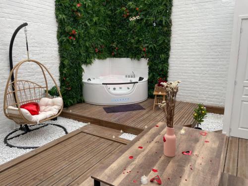 patio con bañera, silla y mesa en Green Love Suite, en Tourcoing