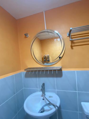 a bathroom with a round mirror above a sink at Saekyung Village1, Phase 3, Marigondon, Lapu-Lapu City, Cebu in Lapu Lapu City