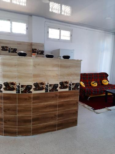 Pokój z drewnianymi półkami w pokoju z kanapą w obiekcie Bel appartement avec vue sur la baie d'Alger w mieście Husseïn Dey