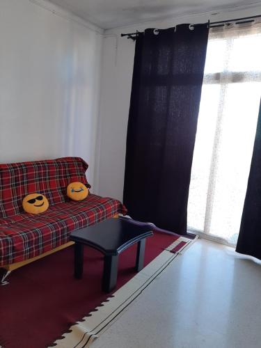 a living room with a couch and a table at Bel appartement avec vue sur la baie d'Alger in Husseïn Dey